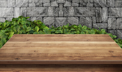 Empty rustic wooden table in front of a textured stone wall with lush green foliage. Ideal natural background for product displays, food photography, or advertising concepts.