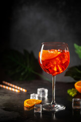 Aperol spritz cocktail in glass with fresh orange on dark background