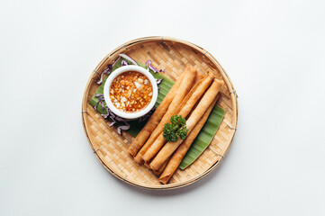 Crispy Golden Spring Rolls with Dipping Sauce on Bamboo Plate