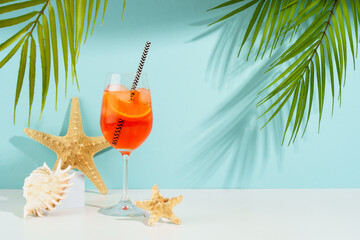 Aperol Spritz, traditional summer cocktail at blue background.