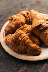 Golden Brown Croissants on Rustic Wooden Plate