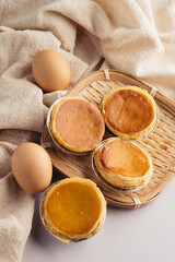 Golden Egg Tarts on Bamboo Tray with Eggs and Fabric