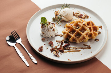 Golden Waffles with Pecan Nuts and Ice Cream on Speckled Plate