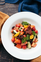 Overhead Shot of a Colorful Salad with Tomatoes and Citrus in a White Bowl