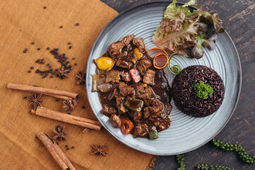 Overhead View of Dark Brown Beef Stir Fry with Black Rice and Herbs