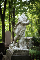 Obraz premium Weathered monument of headless marble child statue stands in quiet cemetery