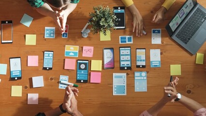 Creative team sitting and discussing while brainstorm about Ux Ui design mobile phone interface. People planning strategy start up project while planning a strategy at business meeting. Convocation.