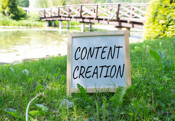 Content creation symbol. Concept word Content creation on white chalk blackboard. Beautiful meadow background. with bridge. Business and Content creation concept. Copy space.