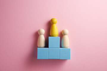 Wooden human figure standing on podium ranking for winner in business and sports competition.