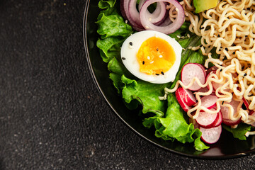 Vegetarian noodle bowl avocado, noodles, egg, vegetables tasty snack fresh delicious gourmet food background on the table rustic food top view copy space keto and paleo diet vegetarian food