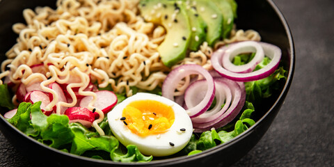 Vegetarian noodle bowl avocado, noodles, egg, vegetables tasty snack fresh delicious gourmet food background on the table rustic food top view copy space keto and paleo diet vegetarian food