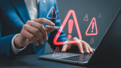 Protect your data now! Businessman addressing urgent security alerts on laptop with red warning signs, ensuring data privacy and system integrity
