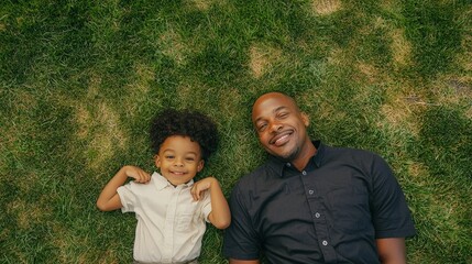 Fototapeta premium A father and son share a joyful moment lying on the grass, enjoying the sunshine and each other's company.