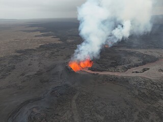 4K Aerial Drone Footage of an Active Volcanic Eruption with Lava Flow and Smoke over a Rugged Lava Field