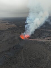 4K Aerial Drone Footage of an Active Volcanic Eruption with Lava Flow and Smoke over a Rugged Lava Field