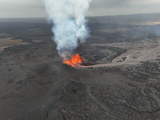 4K Aerial Drone Footage of an Active Volcanic Eruption with Lava Flow and Smoke over a Rugged Lava Field