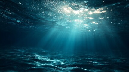 Sunlight streaks pierce the depths of the ocean, creating an ethereal blue underwater scene