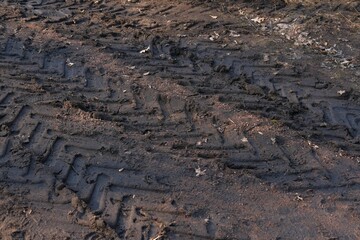 Tire tracks of car or truck on muddy field or dirt road after rain. Driving in bad conditions concept. Season specific in car maintenance. Vehicle cross-country ability in different weather