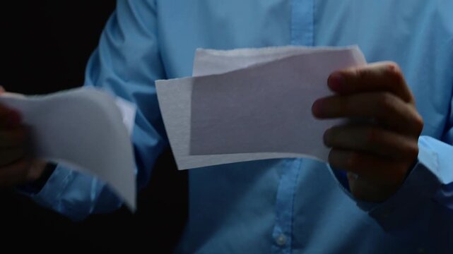 Businessman in blue shirt tears white sheet of paper into small pieces and hands them to me.
Problems at work and torn sheet of paper from anger.
Failed deal and broken contract close-up