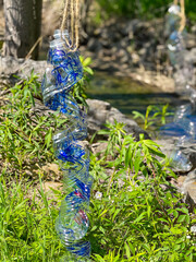 Obraz premium Twisted Plastic Bottle Hanging as Eco-Friendly Garden Decoration