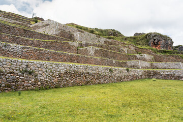 Ancient Inca stone terraces at the archaeological site of Chinchero, Peru against misty Andean mountains