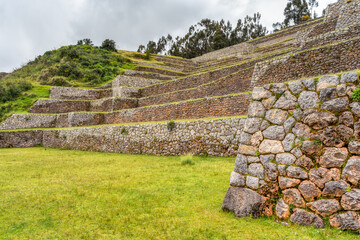 Ancient Inca stone terraces at the archaeological site of Chinchero, Peru against misty Andean mountains