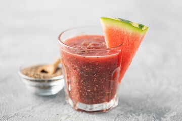 Watermelon juice with chia seeds in a glass on the table. Vegan summer drink