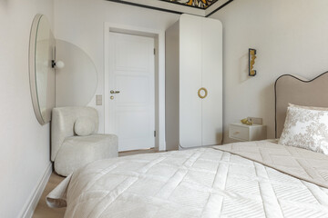 Cozy Bedroom with Round Mirror and Soft Armchair