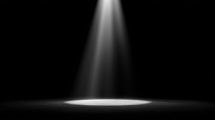 Dramatic black background with single spotlight illuminating empty stage
