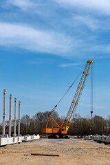 This image shows a large yellow crane in the foreground which appears to be a mobile crane possibly used for construction or heavy lifting