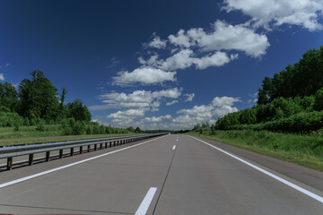 Road view on a summer day. Highways and bridge, roadside and white road line markings.