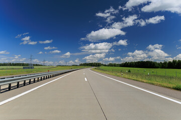 Road view on a summer day. Highways and bridge, roadside and white road line markings.
