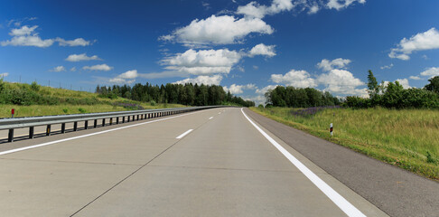 Fototapeta premium The road on a summer day. Beautiful landscape, road markings, roadsides and road lines.
