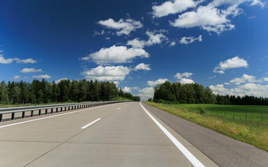 Road view on a summer day. Highways and cars, roadside and white road line markings.
