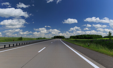 Road view on a summer day. Highways and cars, roadside and white road line markings.