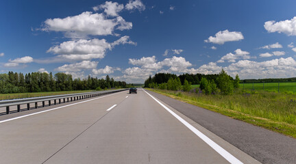 Naklejka premium Road view on a summer day. Highways and cars, roadside and white road line markings.
