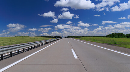Road view on a summer day. Highways and bridge, roadside and white road line markings.