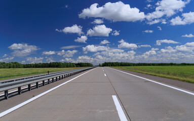 Fototapeta premium Road view on a summer day. Highways and cars, roadside and white road line markings.