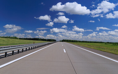 Road view on a summer day. Highways and cars, roadside and white road line markings.
