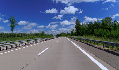 Road view on a summer day. Highways and bridge, roadside and white road line markings.