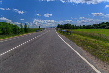 Road view on a summer day. Highways and bridge, roadside and white road line markings.