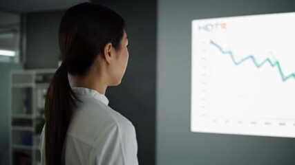 Businesswoman analyzing data trends on a digital screen in a modern office with plants in background - Powered by Adobe