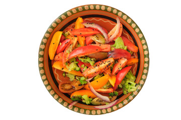 Sliced tomato in rustic bowl. Tomatoes in a clay plate isolate on white background. Salad of fresh tomatoes and other vegetables. Top view.