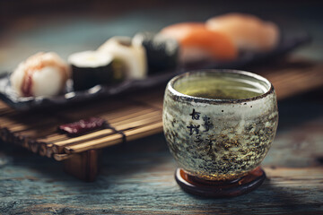 Japanese Tea and Sushi Still Life: Traditional Cup, Fresh Nigiri, and Rustic Wood Texture (Authentic Cuisine, Asian Food Culture)