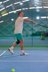 Fototapeta premium Man playing tennis on a court