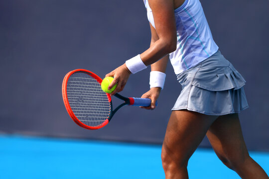 Female tennis player preparing serve with racket and ball on outdoor court