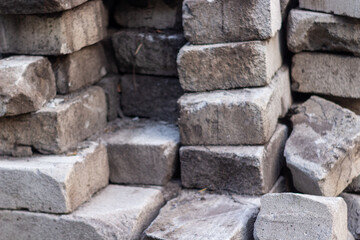 Pile of weathered natural stone bricks offering a rough textured appearance with various shapes and subtle earthy tones ideal for construction materials backgrounds or geological themed designs