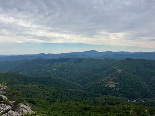 Fototapeta premium Stunning view soaring above the lush Cévennes forest under a vibrant sky painted with warm hues. Perfect for hiking (gr70, chemin de stevenson) and landscape photography.