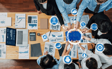 A dynamic business meeting scene showcasing diverse teams engaged in analyzing data visuals and reports while integrating CRM strategies for effective decision-making. Amity