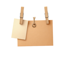 Two beige notes pinned to a board with clothespins